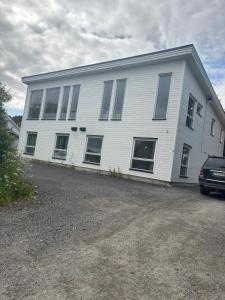 una casa bianca con un'auto parcheggiata davanti di Kroken3 the apartment a Gravdal