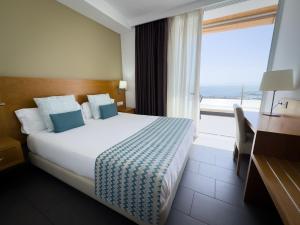 a hotel room with a bed and a large window at Holiday Club Puerto Calma in Puerto Rico de Gran Canaria