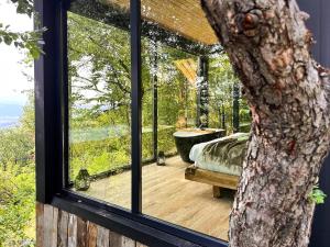 a room with a window and a tub on a deck at ForestView 1- Romantic Cabin for 2 in Fuereşti