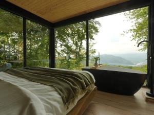 a bedroom with a bath tub in front of a window at ForestView 1- Romantic Cabin for 2 in Fuereşti