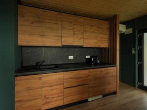 a kitchen with wooden cabinets and a sink at ForestView 1- Romantic Cabin for 2 in Fuereşti