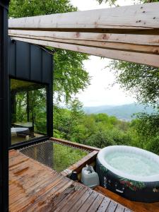 a hot tub on the deck of a tree house at ForestView 1- Romantic Cabin for 2 in Fuereşti