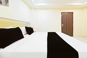 a white bed with black pillows in a room at Hotel O Sanath Nagar Near Railway Station in Hyderabad +14 photos