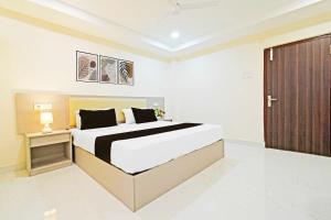 a bedroom with a large bed and a wooden door at Hotel O Sanath Nagar Near Railway Station in Hyderabad