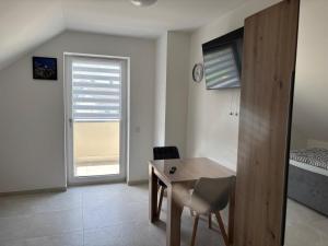 a room with a desk and a bed with a window at Boardinghaus Koucha - Wohnen auf Zeit in Neuburg an der Donau