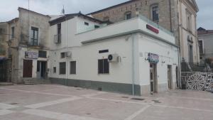 un edificio blanco en un estacionamiento junto a los edificios en Bar Centrale Zichella, en Lacedonia