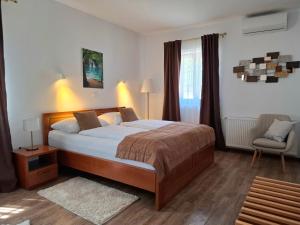 a bedroom with a large bed and a chair at B&B Plitvice Lakes Villa Mija in Plitvica selo