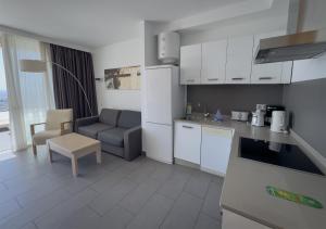 a kitchen and living room with a couch and a table at Holiday Club Puerto Calma in Puerto Rico de Gran Canaria