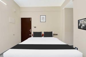 a bedroom with a large bed with black and white sheets at Collection O Padmanabhaswamy Temple Trivandrum in Trivandrum