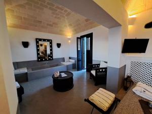 a living room with a couch and a table and a tv at Il Baglio sull'Acqua in Favignana
