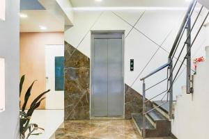 a glass elevator in a lobby with a staircase at Townhouse Oak Pune Ramwadi Metro Station in Pune