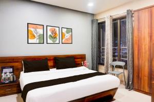 a bedroom with a large bed and a window at Townhouse Oak Pune Ramwadi Metro Station in Pune