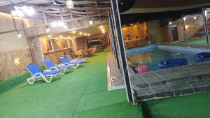 a swimming pool with blue chairs and a swimming pool at شاليهات تلال اشتفينا in Ajloun