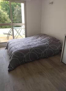 a bed with a black comforter in a room at Studio Saint Georges de Didonne in Saint-Georges-de-Didonne