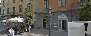 uma rua com um prédio e pessoas andando no passeio em Sole e Mare em Salerno