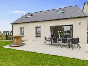 a patio with a table and chairs in front of a house at Maison familiale pour 10 à Fréhel avec jardin in Frehel