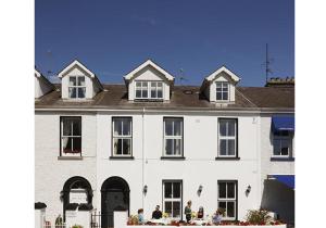 a white house with people sitting outside of it at The Townhouse Strand in Dunmore East