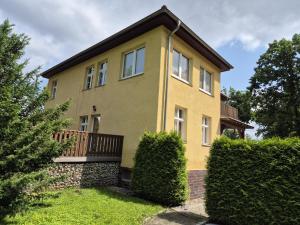 ブランデンブルク・アン・デア・ハーフェルにあるHaus am Wendseeのバルコニーと茂みのある黄色い家