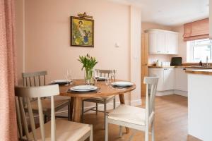 een keuken en eetkamer met een houten tafel en stoelen bij Wall Cottage in Coldstream