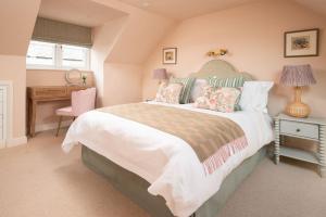 een slaapkamer met een groot bed en een bureau bij Wall Cottage in Coldstream