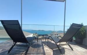 two chairs and a table on a balcony at ALTA MARE in Nea Peramos