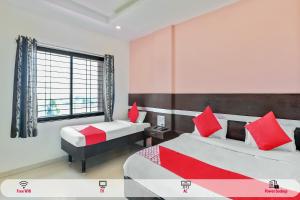 a hotel room with two beds and a window at Hotel O Sai Kohinoor in Shirdi +15 photos