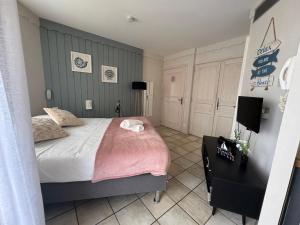 a bedroom with a bed and a tv in it at Appartement Le Beach du Lac d'Annecy avec les pieds dans l eau, plage et ponton privé in Duingt