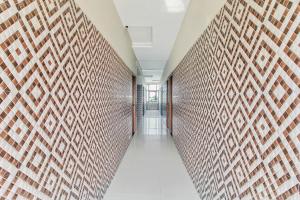 a hallway with a brick wall at Hotel O Sai Kohinoor in Shirdi