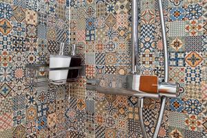 Un baño con una pared de azulejos con ducha. en La Casa de la Alameda, en Málaga 37 fotos más