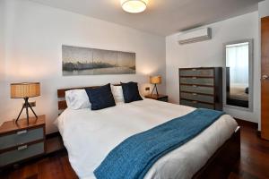 Un dormitorio con una cama grande con una manta azul. en La Casa de la Alameda, en Málaga