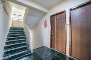 a stairway with a wooden door and a staircase at Hotel O Megha Villa in Gorhe