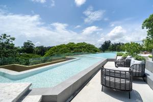 a swimming pool with two chairs on a patio at Laguna Beachside Apartment 300 meters to the Bangtao Beach in Bang Tao Beach