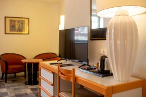 a hotel room with a desk with a coffee maker on it at Hôtel Paradis in Lourdes