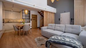 salon z kanapą i stołem oraz kuchnia w obiekcie Apartamenty Sun & Snow Ustroń Przy Rynku w Ustroniu