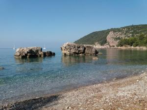 two rocks in the water next to a beach at Apartment for 2 in the house in Sutomore