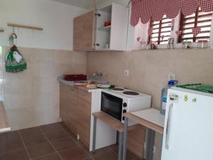 a small kitchen with a stove and a refrigerator at Apartment for 2 in the house in Sutomore +20 photos