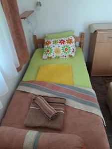 a small green bed with towels and a pillow at Apartment for 2 in the house in Sutomore