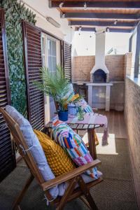 a patio with a table and a chair and a fireplace at House Pachamama in Olhão