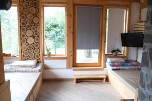 a living room with two windows and a tv in it at ABC Apartma Kočevsko in Kočevje
