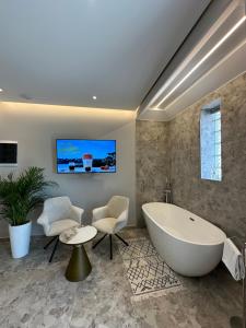 un bagno con vasca, tavolo e sedie di Jericho rooms a Sarandë