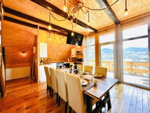 a dining room with a wooden table and chairs at Lake Retreat Colibita in Colibiţa