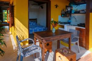 a kitchen and dining room with a table and a table and chairs at Casa Manhapeba in Ilha de Boipeba