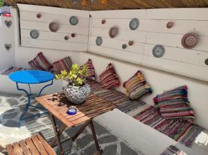 a room with a bench and a table with pillows at Hara's House 2 in Gerakini