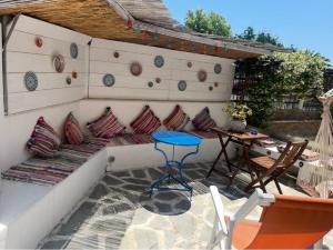 a patio with a table and pillows on a wall at Hara's House 2 in Gerakini