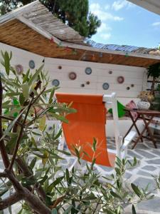 an orange chair sitting under a pergola on a patio at Hara's House 2 in Gerakini