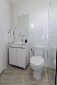 ein weißes Badezimmer mit Toilette und Waschbecken in der Unterkunft House Dinavast Bungalow in São João da Pesqueira