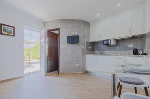 eine Küche mit Theke und Tisch mit Stühlen in der Unterkunft House Dinavast Bungalow in São João da Pesqueira