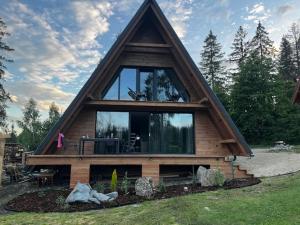 a house with a pointed roof with a large window at Luxusný CHALET DANIELS Tatranská Štrba in Štrba