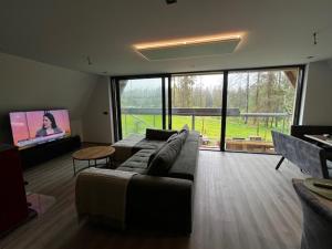 a living room with a couch and a flat screen tv at Luxusný CHALET DANIELS Tatranská Štrba in Štrba
