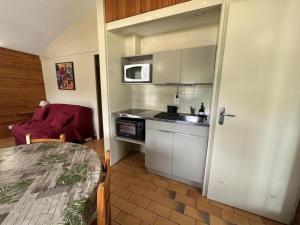 a small kitchen with a sink and a microwave at Les bruyères in Brocas